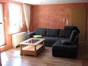 Wohzimmer mit Schlafsofa, Zugang zum Balkon