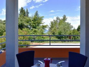 Der Blick von der Terrasse auf den Parkplatz, die umliegende Natur und das Meer in der Ferne.