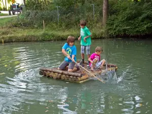 Kinder beim Floßfahren Kinder beim Floßfahren