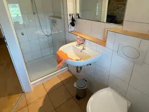 Dusche mit Glaswand im hellen Badezimmer