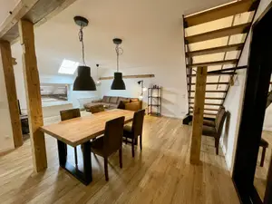 Schöner Holztisch im Wohnbereich mit Sofa und Treppenaufgang