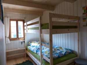 kleines zimmer mit etagenbett und schrank