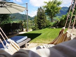 Liegestühle, Hängesessel, Tisch mit 6 Stühlen sowie Sonnenschirm auf Terrasse