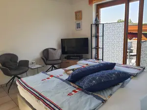 Schlafzimmer mit Fernseher und Zugang zum Balkon