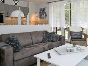 Wohnzimmer mit Schlafcouch und Korbsessel