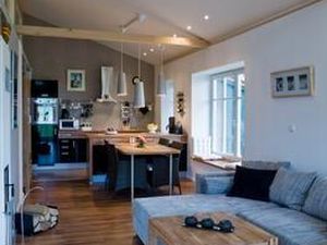 helles Wohnzimmer mit offenen Balken und Küchenanschluss