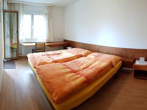 Schlafzimmer mit Doppelbett, Kleiderschrank und Schreibtisch