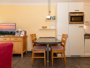 Wohn-Essbereich mit Couch, Sitzgelegenheit und Küchenzeile