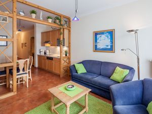 Wohnzimmer mit Schlafcouch und Sessel