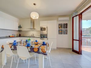 Vollständig ausgestattete Küche mit Esstisch und Zugang zum Balkon