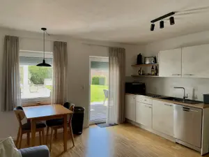 Ferienwohnung 16 - Wohn-/Essbereich mit Küchenzeile und Terrassenzugang