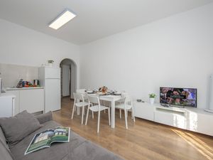 Wohnzimmer mit Küchezeile, Esstisch, Sofa und Fernseher