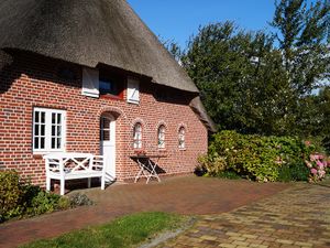 Friesenbänke am Haus laden zum Klönschnack in der Sonne ein.