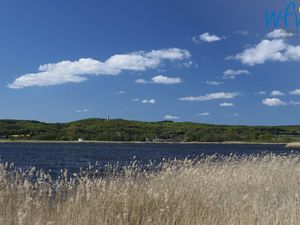 Einen Steinwurf von der Ferienwohnung entfernt tut sich der Blick über den Neuensiener See zum Jagdschloss Granitz auf.