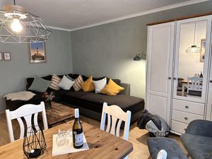 Wohnzimmer mit Sofa, Kleiderschrank und Esstisch