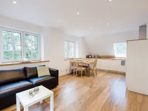 gemütliches Sofa mit Esstisch und Küche im Hintergrund