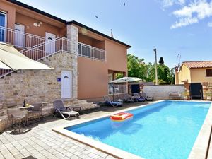 Das Äußere der Wohnung mit Balkon, Swimmingpool im Garten.