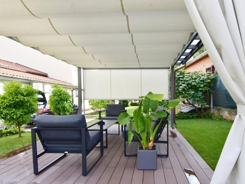 Die schöne überdachte Terrasse im Garten ist mit Gartenmöbeln ausgestattet.
