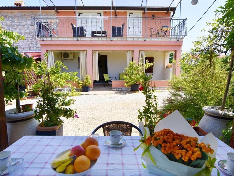 Die Vorderseite des Hauses und die Terrasse der Erdgeschosswohnung