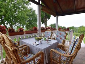 Die Terrasse ist mit Gartentisch und Stühlen ausgestattet, um Kaffee zu genießen.