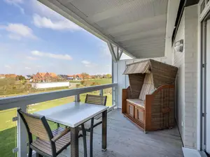 Überdachter Balkon mit Sitzgelegenheit und Strandkorb
