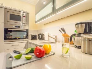 offene Küche mit Mikrowelle, Backofen, Spüle, Kühlschrank und Geschirrspüler