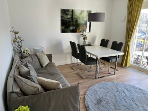 Wohnbereich mit Sofa, Esstisch und Bestuhlung