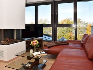 Wohnbereich mit Sofa, TV, Couchtisch und Gaskamin