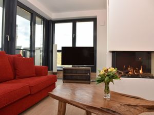 Wohnbereich mit Sofas, TV, Couchtisch und Gaskamin