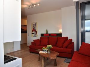 Wohnbereich mit Sofas, TV, Couchtisch und Gaskamin