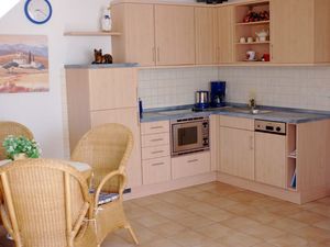 offene Küche mit Spülmaschine, Herd, Mikrowelle und Kühlschrank