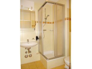 Badezimmer mit WC, Dusche, Waschbecken und Spiegel