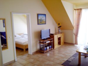 Sideboard mit TV und Blick in das Schlafzimmer