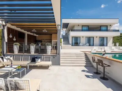 Eine voll ausgestattete Sommerküche mit Grill und mit TV, ein überdachter Essbereich, ein separates WC