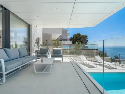 Ein paar Stufen über dem Pool befindet sich ein überdachter Terrassenbereich mit einer Lounge-Ecke