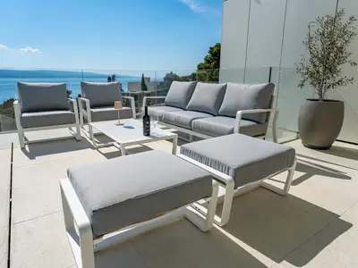 Auf der Poolebene befindet sich ein überdachter Terrassenbereich mit einer Lounge-Ecke