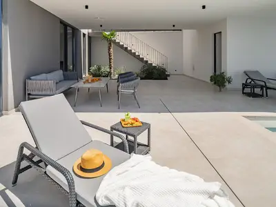 Ein Sonnendeck mit sechs Liegen, einer Außendusche und einem gemütlichen Loungebereich zum Entspannen