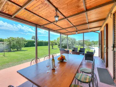 Die ausgestattete Pergola, die auf den Rasen hinausgeht und mit der Küche verbunden ist
