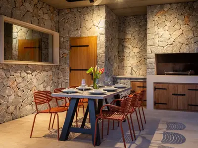 Es gibt einen überdachten Essbereich im Freien mit einem Grill