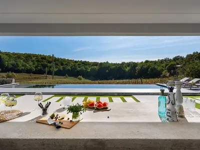  2 Wohnbereichen, 2 voll ausgestatteten Küchen, einem beheizten 44 m2 großen Infinity-Pool 