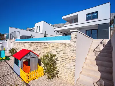 Kinderecke unterhalb des Poolber. , eingezäunt mit kleinem Trampolin,Haus,Rutsche