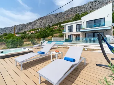 Der Außenbereich bietet einen privaten und beheizten 32 m2 großen Infinity-Pool mit chlorfreiem System, einen Whirlpool, zwei Sonnendeckbereiche, 8 Liegestühle, ein gemütliches Außensofa, 1 Sonnenschirm und eine Außendusche