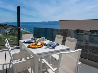 Überdachter Esstisch im Freien mit Meerblick