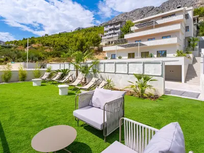 Ein zusätzlicher Sonnendeckbereich befindet sich ein paar Stufen über dem Poolbereich und ist mit einem Kunstrasenbereich bedeckt, der eine Lounge-Ecke, Entspannungsstühle und Sonnenschirme bietet