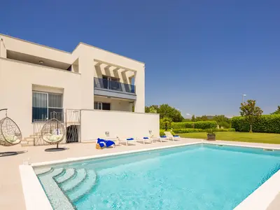 a private and heated, 5m x 10m swimming pool with a spacious sun deck area