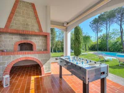 Die ausgestattete Loggia, mit Holzofen, offen auf dem Rasen in der Nähe des Pools