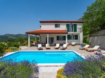 Essbereich im Freien mit Grill und Poolblick