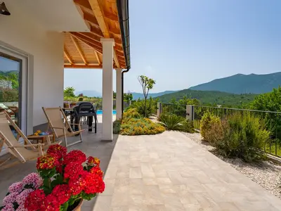 Der Sitzbereich im Freien befindet sich neben dem Pool und bietet einen atemberaubenden Blick auf die Berge.