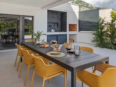 a covered dining area with a barbecue (wood and charcoal)