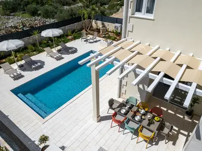 Der Essbereich im Freien befindet sich neben dem Grill und dem beheizten Pool.